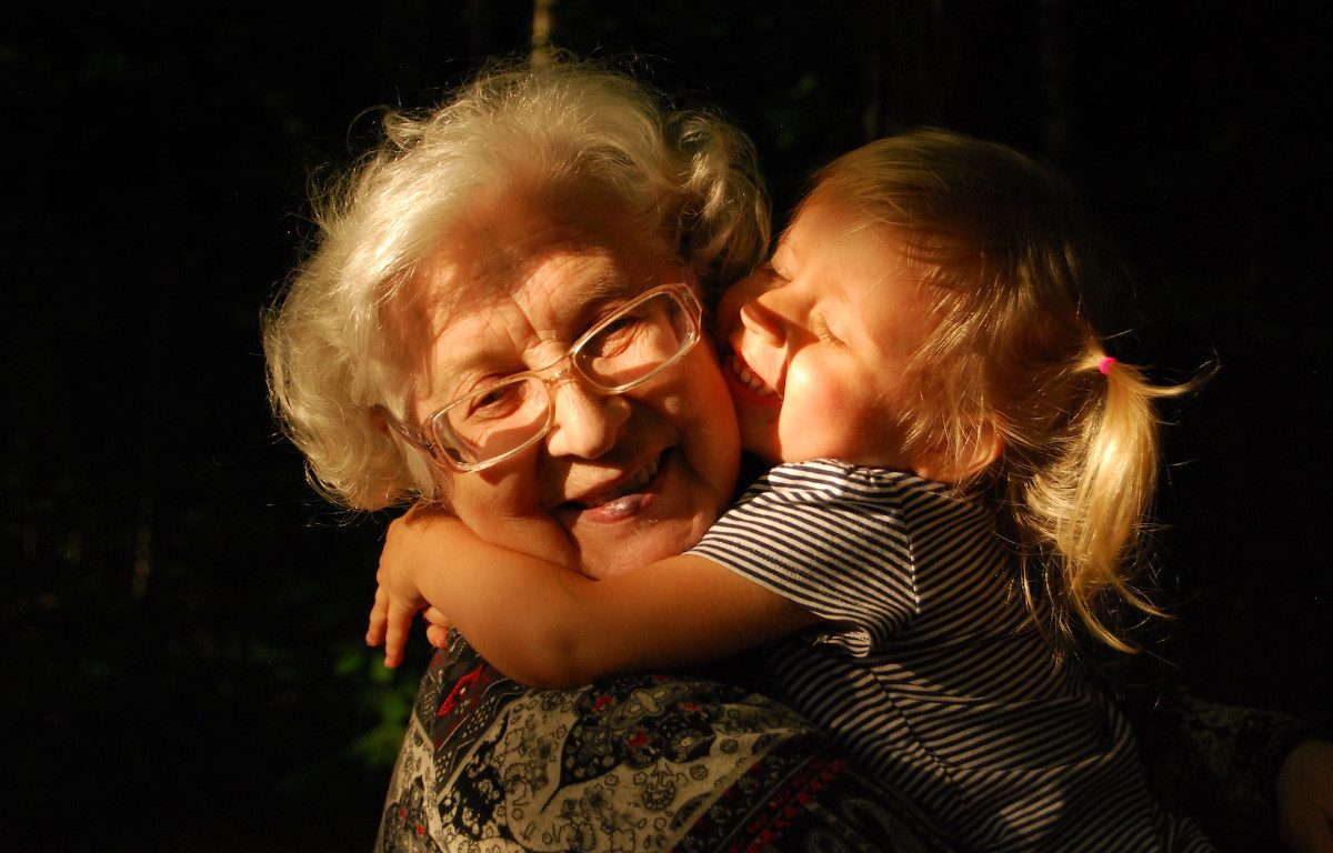 Older woman getting hugged by toddler.