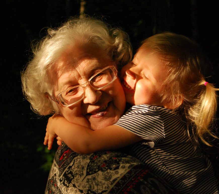 Older woman getting hugged by toddler.