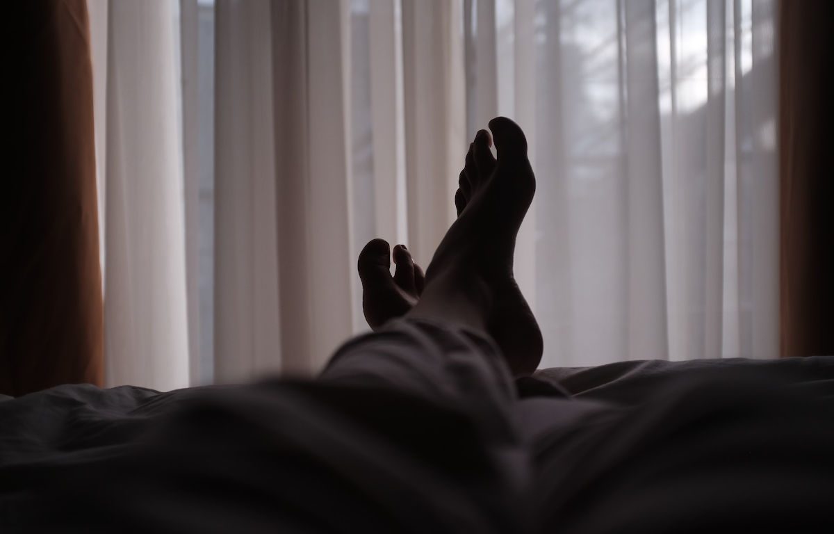 View of someone's legs and feet laying down.