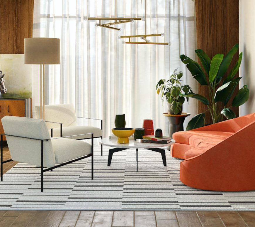 Living room with natural light coming through thin, white curtains, supplemented by a standing lamp and two hanging light fixtures. Wood floors with area rug create a contrast of texture. Couple of plants in the corner add a natural element. Bright coral-coloured couch across from two white chairs, and a round marble coffee table. Multiple vases, sculptures, and two paintings finish the room with splashes of colour.