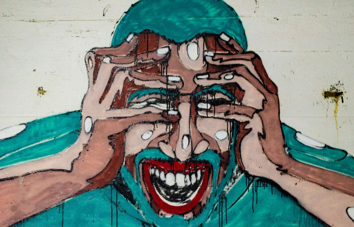 Graffiti image of man triggered with an emotional reaction, grabbing his head with his hands.