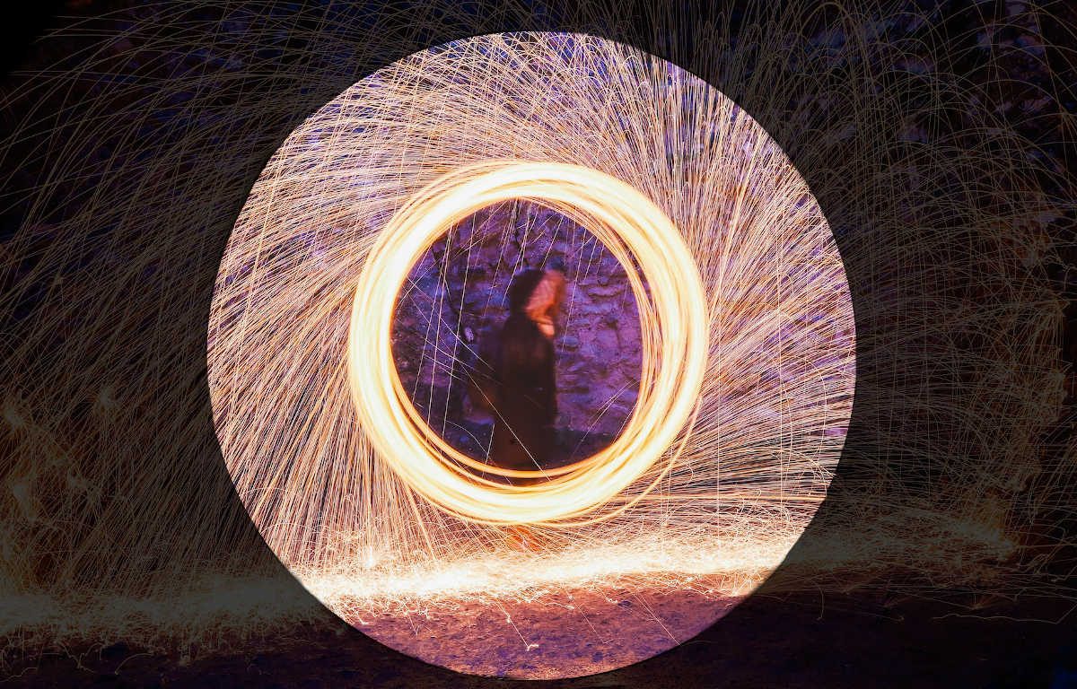 Trailing light creates the illusion of three concentric circles with a blurry image of person in the middle.