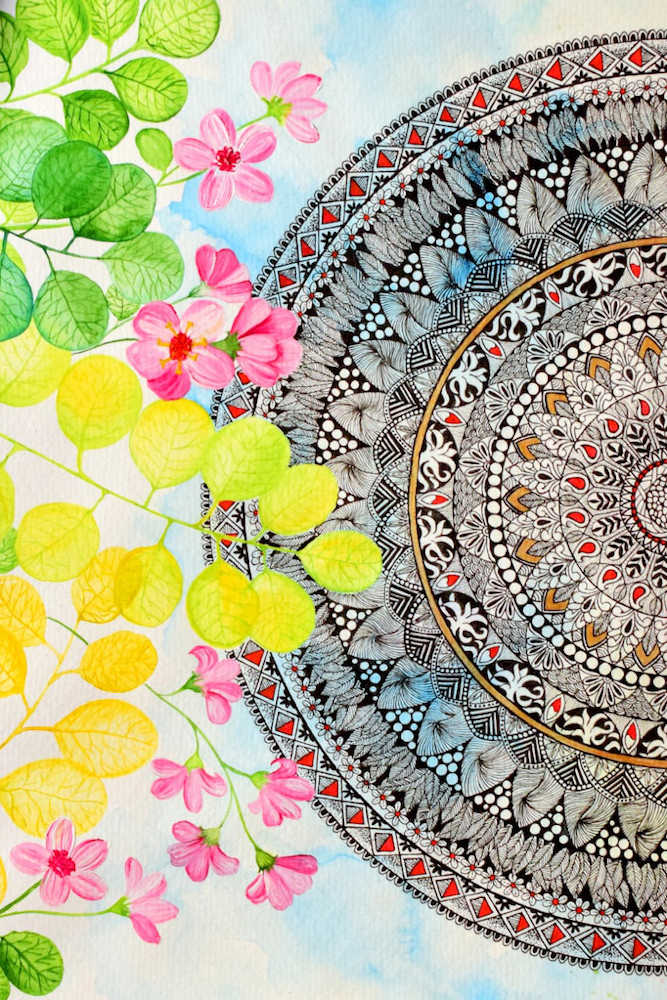 Mandala black ink drawing on right side with orange and red highlights. Background is blue watercolour sky. Foreground has leaves in yellow and green with pink flowers.