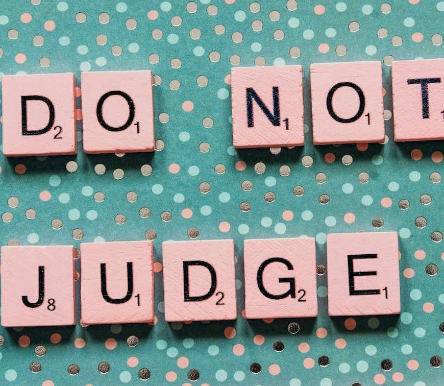 Teal polka dot background with pink scrabble tiles spelling out "Do Not Judge".