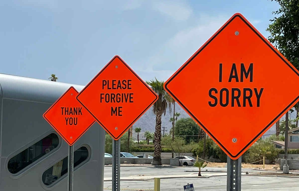 Three (3) orange, diamond-shaped traffic signs with phrases: "I am sorry", "Please forgive me", and "Thank you".