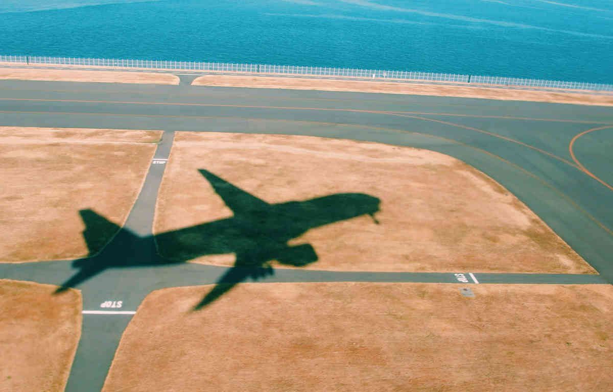 Shadow of a plane on the runway during a take-off on a sunny day.
