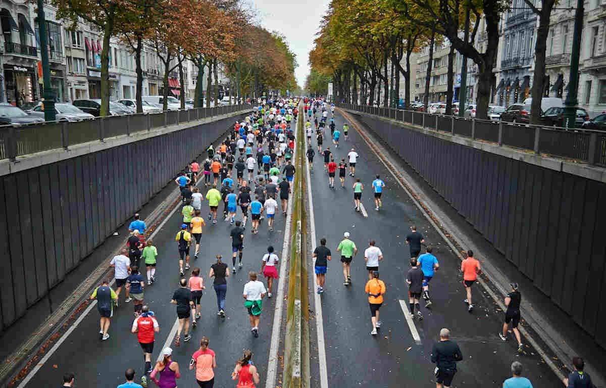 Marathon runners exiting a tunnel road.