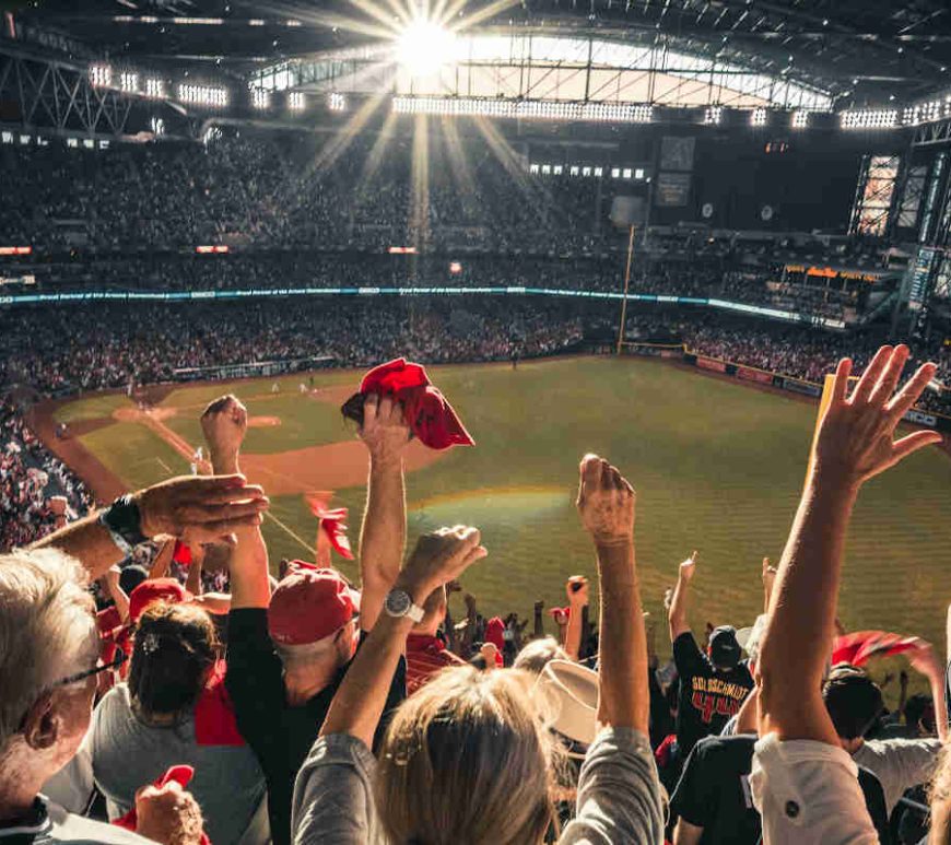 Fans cheering in the stands during a baseball game.