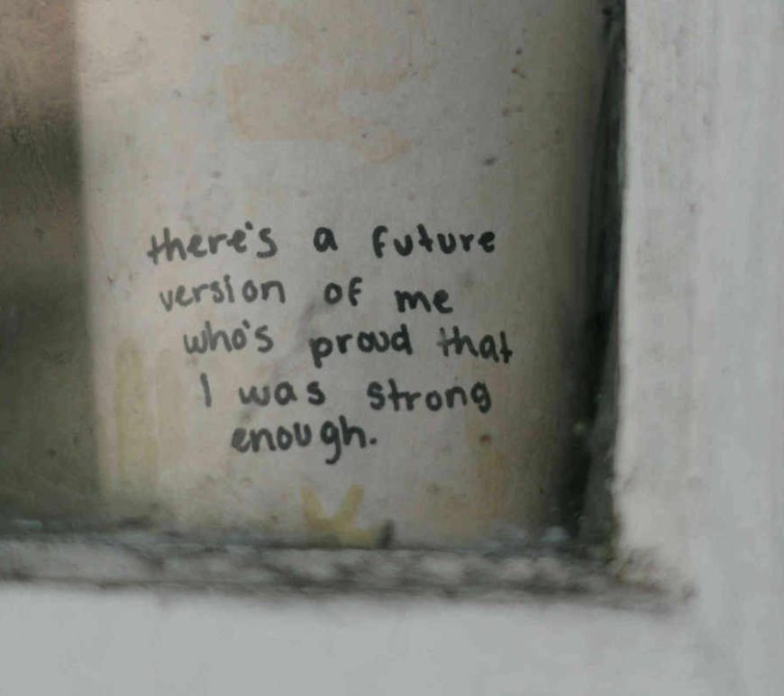 Text written in black marker on a coffee cup, on window ledge stating "there's a future version of me who's proud that I was strong enough."